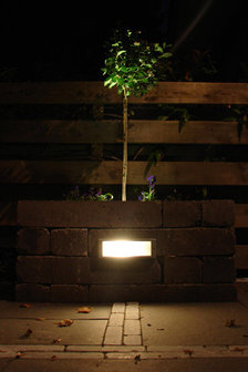 Sfeerfoto van een buiteninbouw wandlamp